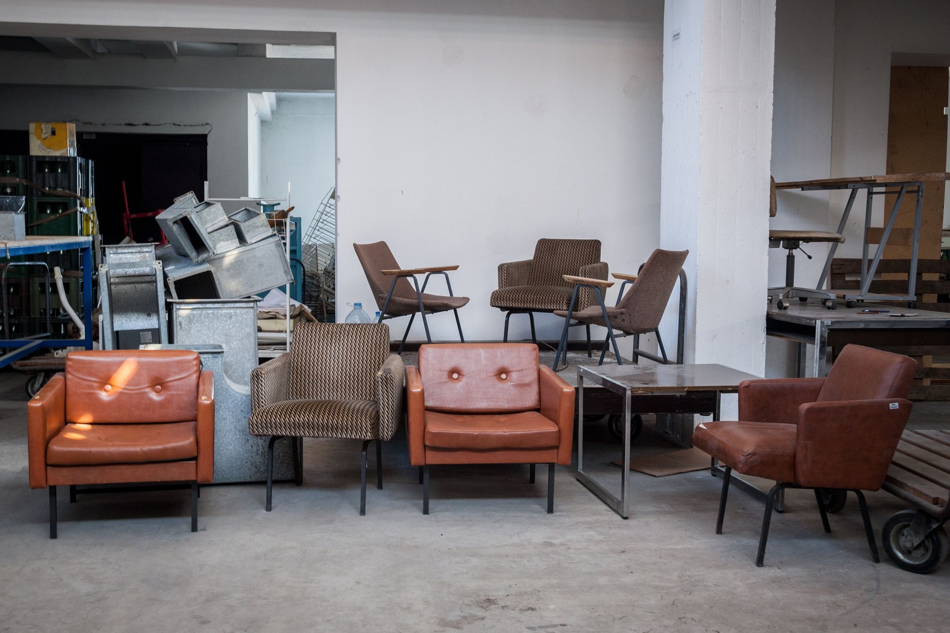 Vintage leather armchairs from the 70's for sale in the warehouse of an antique dealier in a flea market